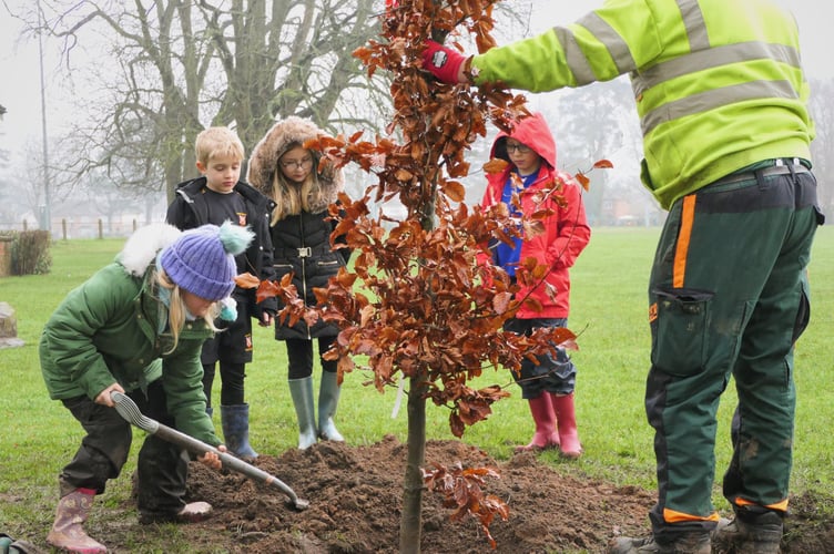 Children patting down soil.