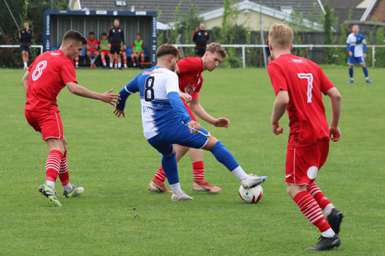 A Chepstow player keeps the ball from Aber players