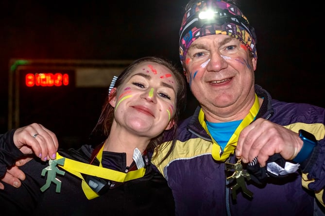 Two happy runners show their medals after the Piercefield Park Night Run