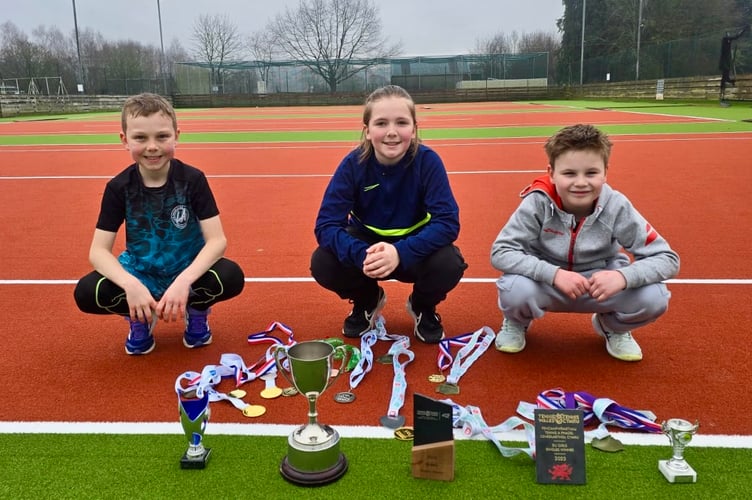 Henry Wyatt (left), Ada Williams (centre) and Solomon Green (right) displaying their medals and trophies at Usk Tennis Club