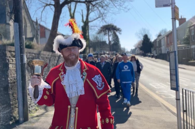 Town Crier Jer Holland leads the parade along Belle  Vue Road.